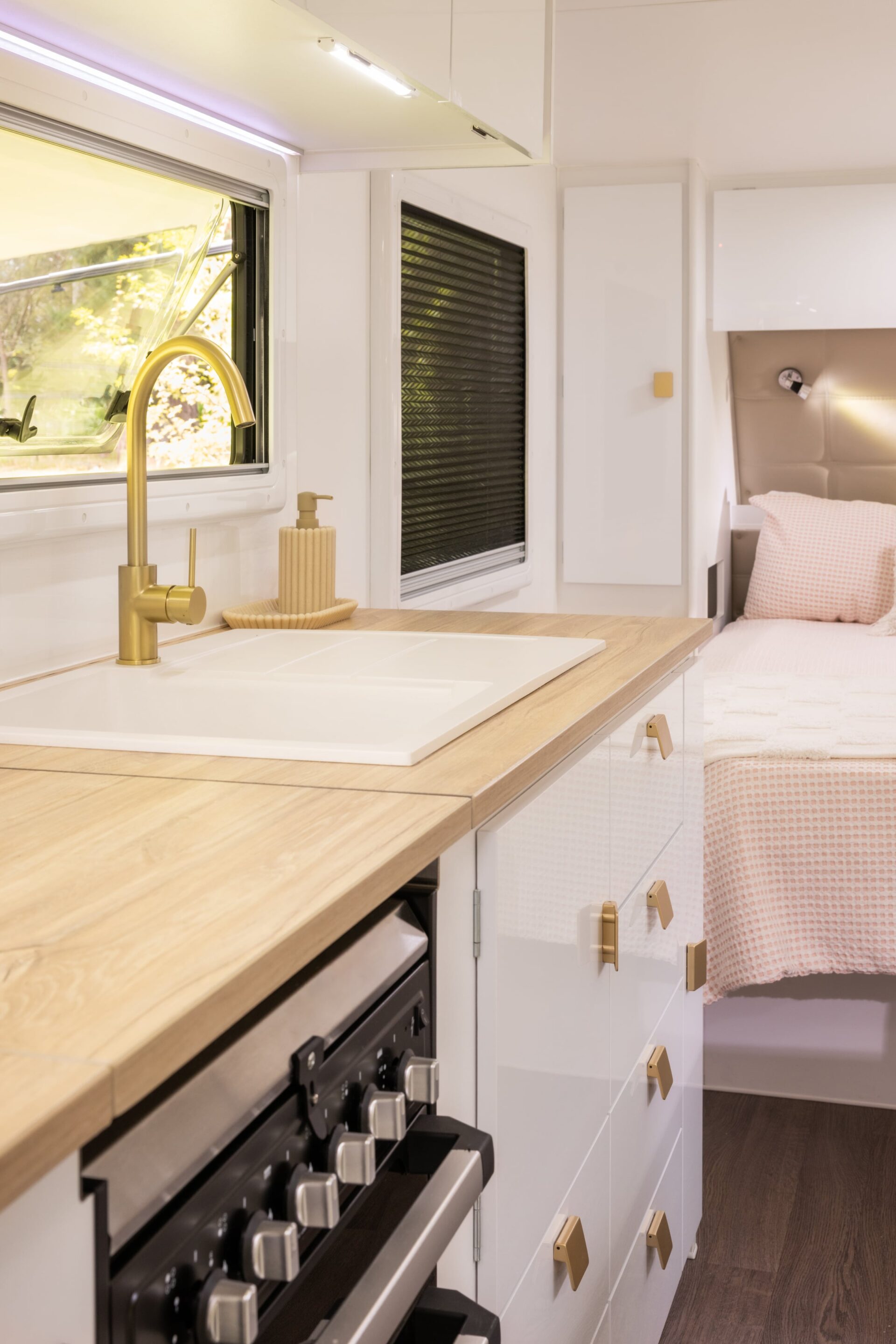 Supreme Classic Tourer kitchen interior — sink and stovetop with bedroom in background