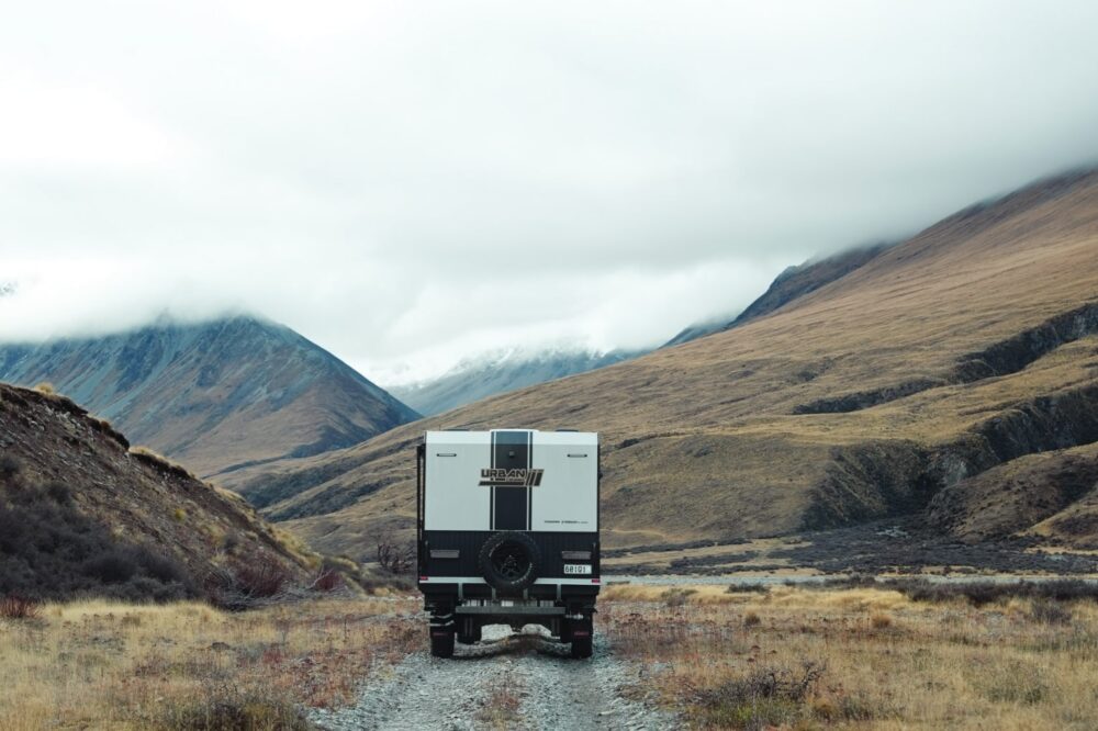Urban Tungsten X-Treme X caravan on a gravel mountain track in alpine landscape — Urban brochure 2026